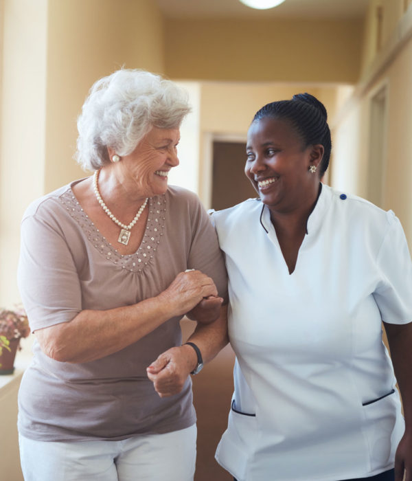 Senior woman walking with a nurse