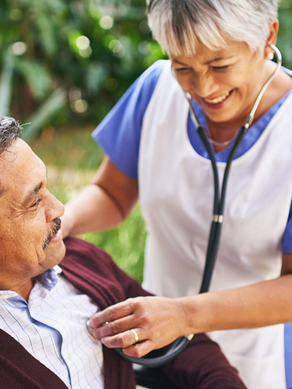 Nurse listening to man's heartbeat with stethoscope