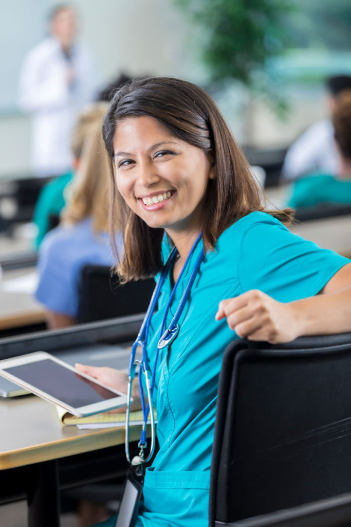 A woman wearing scrubs in a classroom